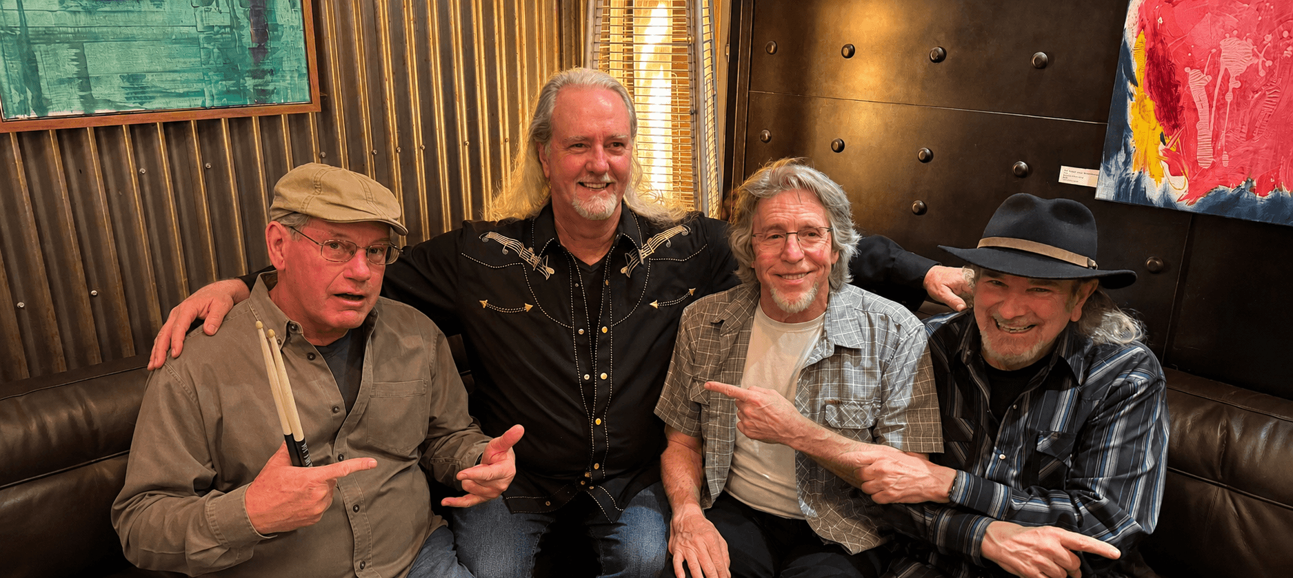 Four American Underdog band members seated together indoors